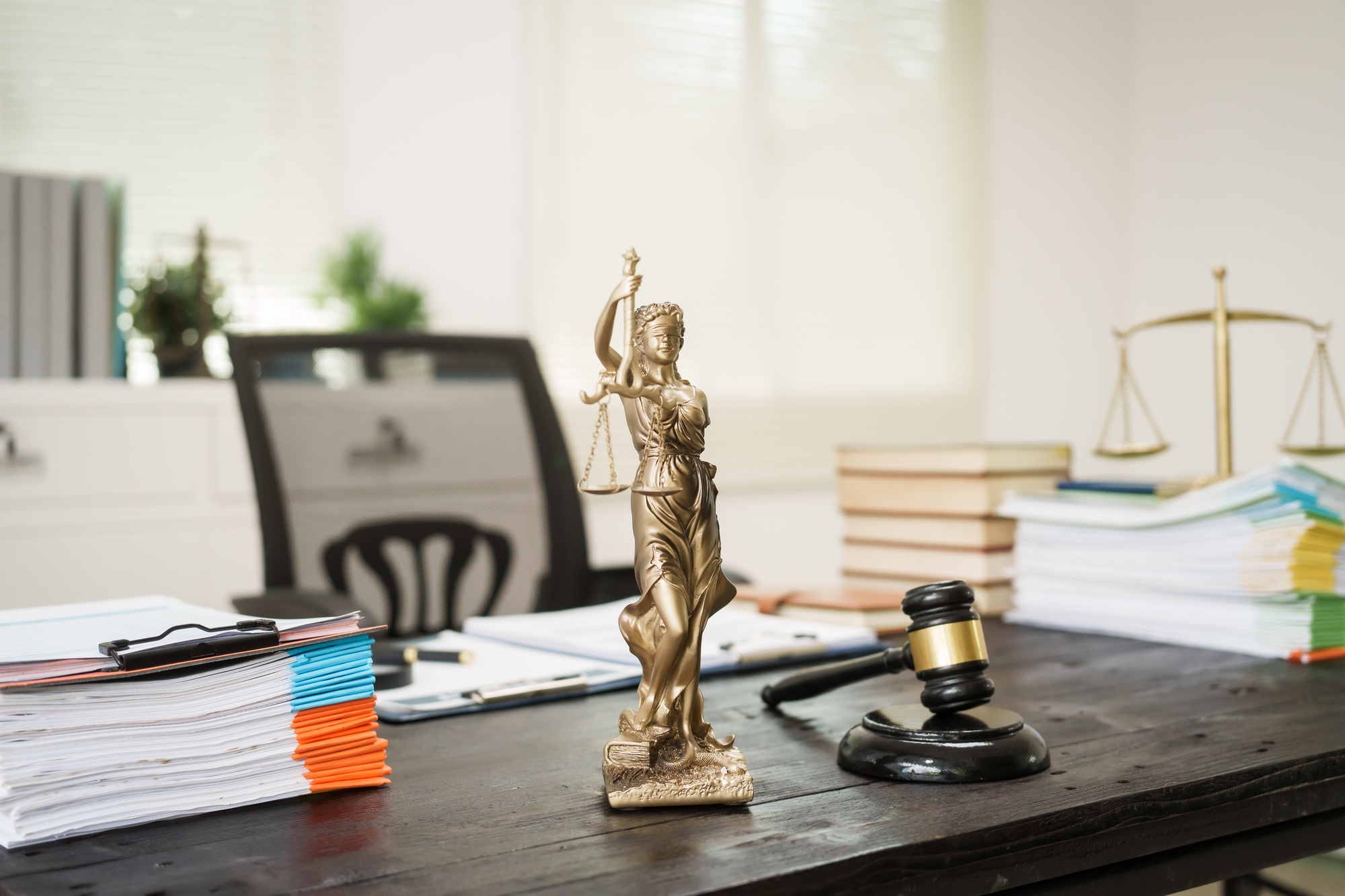 A lawyer's desk in the office is filled with legal documents.The lawyer provides consultations