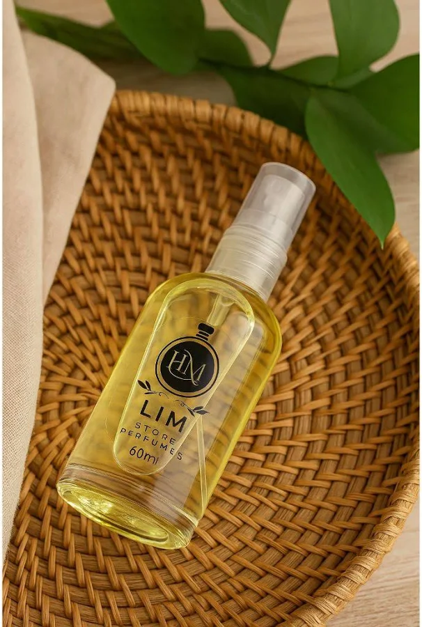 Frasco de perfume Lima & Capim-Santo sobre bandeja de palha, com folha verde ao fundo
